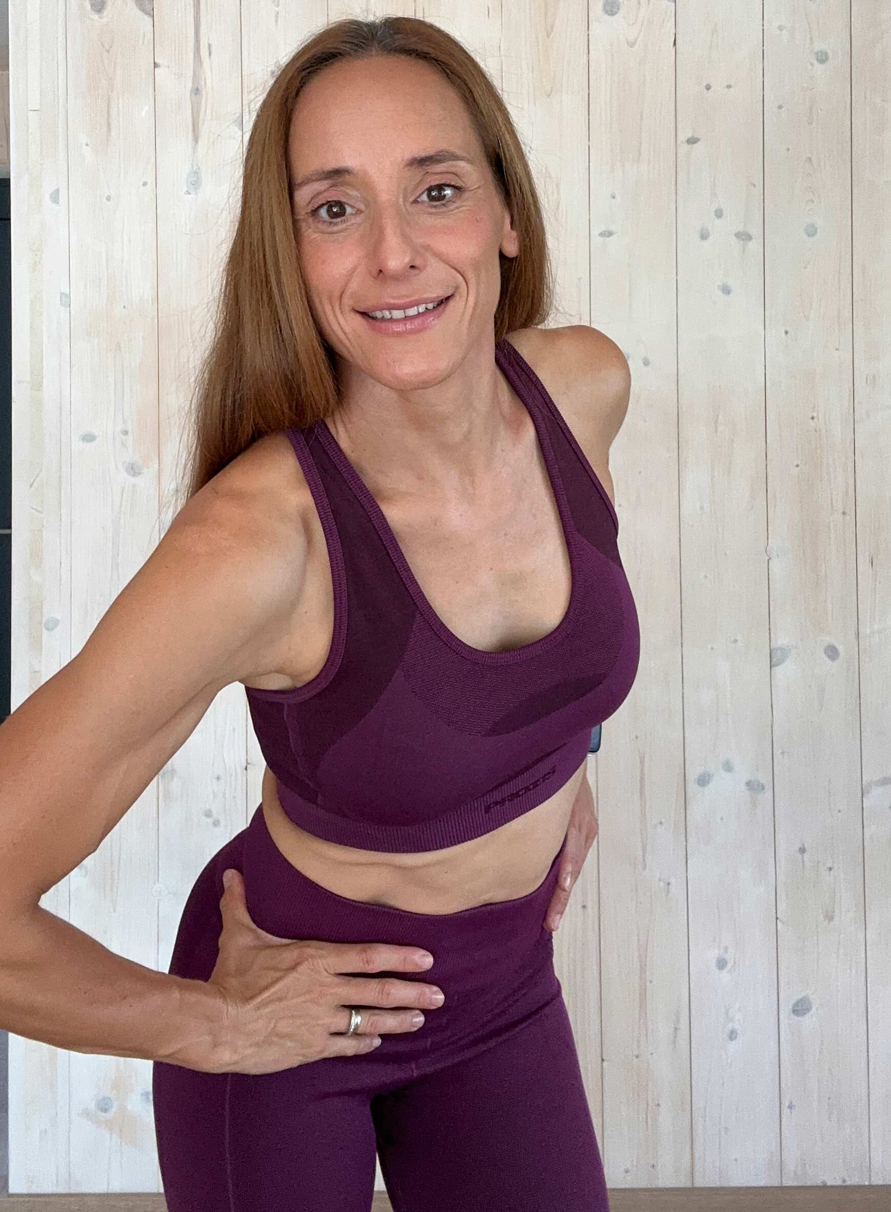 La entrenadora está sonriendo, con un portátil.